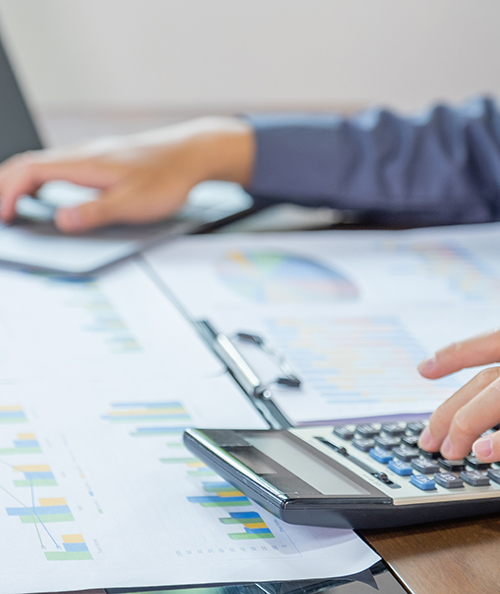 Businessmen bookkeeper hand use calculator and laptop doing account for paying tax on desk in working office.