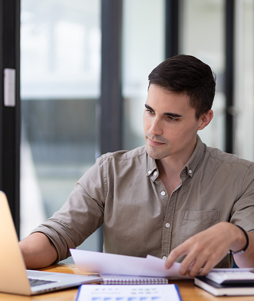 Handsome young businessman in the office serious about work analyzing documents and planning financial accounts.