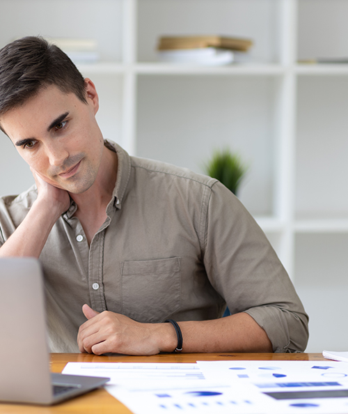 Handsome young businessman in the office serious about work analyzing documents and planning financial accounts.